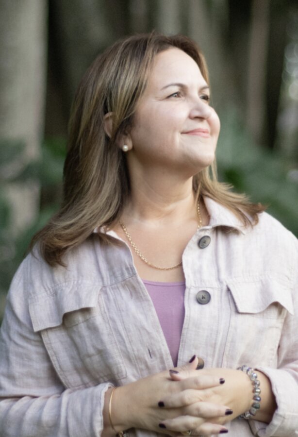 Joyce Granda, DNP — Board-Certified Nurse Coach and Reiki Master, smiling in soft natural light.